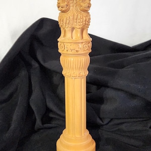 May include: A wooden sculpture of the Ashoka Pillar, a national symbol of India, featuring two lions standing back to back on a cylindrical base.