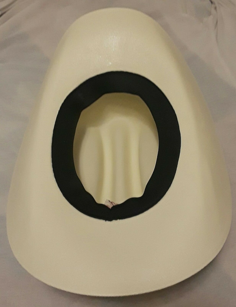 May include: The inside of a white cowboy hat with a black band around the crown.