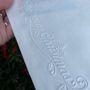 Un sacco di sacchetti di carta Kraft bianca con il messaggio "Buon Natale" per biglietti regalo, feste di Natale.