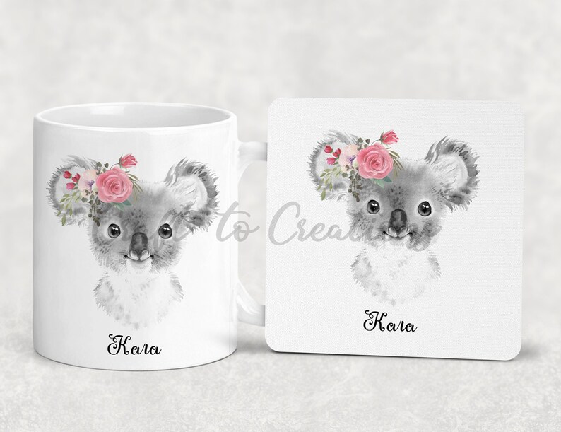 May include: A white ceramic mug and coaster set featuring a grey koala wearing a pink floral crown. The mug and coaster both have the name "Kala" printed on them.