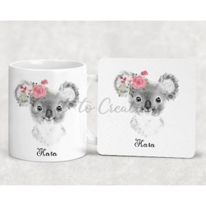 May include: A white ceramic mug and coaster set featuring a watercolour illustration of a koala wearing a pink flower crown. The mug and coaster are personalised with the name "Kara".