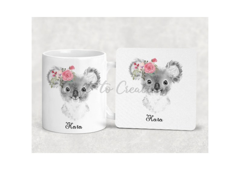 May include: A white ceramic mug and coaster set featuring a watercolour illustration of a koala wearing a pink flower crown. The mug and coaster are personalised with the name "Kara".