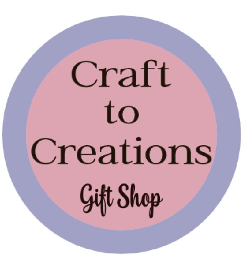 May include: A pink circle with a blue border, the text "Craft to Creations Gift Shop" in black.
