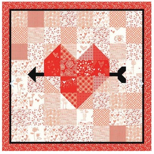 May include: A red and white patchwork quilt with a heart design in the center. The heart is made up of smaller squares of fabric in different patterns. The quilt is surrounded by a red border.