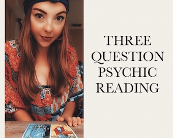 Può includere: Una donna con un turbante blu e una camicia a fantasia floreale è seduta a un tavolo con tre carte dei tarocchi disposte davanti a lei. Le carte sono Il Mago, La Sacerdotessa e Il Mondo. Il testo "THREE QUESTION PSYCHIC READING" è visualizzato su uno sfondo bianco.