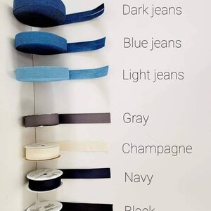 Puede incluir: Una variedad de carretes de cinta en diferentes colores, incluyendo azul oscuro, azul claro, gris, champ&aacute;n, azul marino y negro.