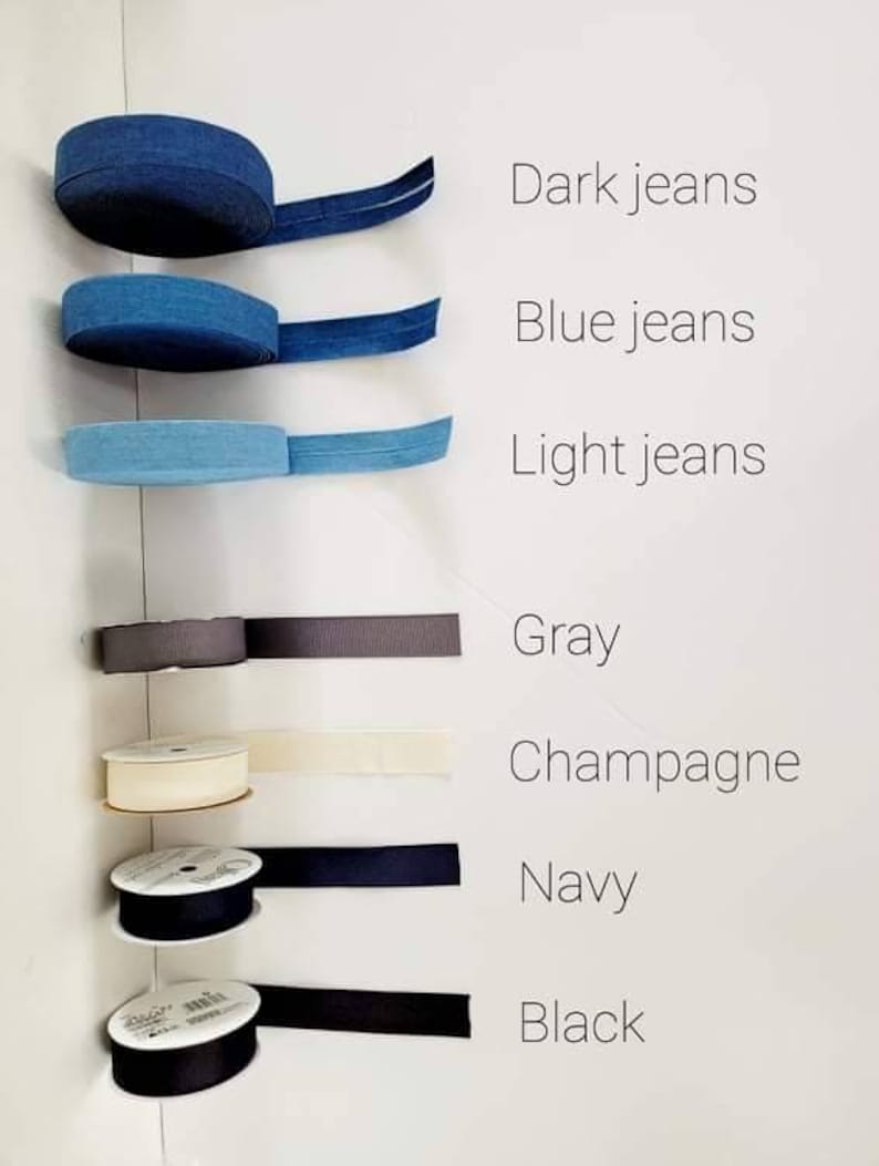 Puede incluir: Una variedad de carretes de cinta en diferentes colores, incluyendo azul oscuro, azul claro, gris, champ&aacute;n, azul marino y negro.