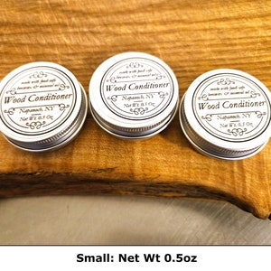 May include: Three small, round, silver-colored metal tins of wood conditioner, each with a white label featuring black text that reads Wood Conditioner, Napanoch, NY, and Net Wt 0.5 oz, along with a description of food-safe beeswax and mineral oil.