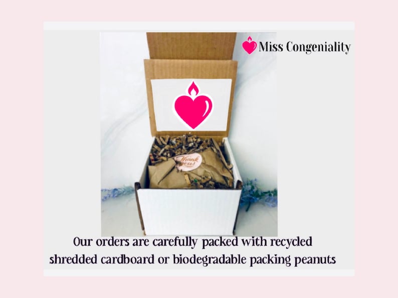 May include: A white box with a brown lid is filled with shredded paper. The lid has a pink heart with a flame on top and the text "Miss Congeniality". The text "Our orders are carefully packed with recycled shredded cardboard or biodegradable packing peanuts" is below the box.