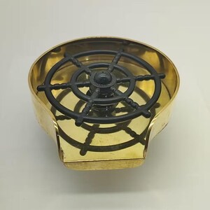 May include: A brass ashtray with a black plastic ship's wheel design in the center.