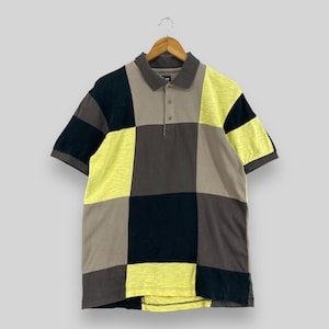 May include: A short-sleeved polo shirt with a checkered pattern in black, brown, and yellow.