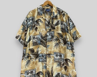 May include: A short-sleeved, beige button-down shirt with a tropical print featuring palm trees, leaves, and ocean scenes. The shirt has a blue collar and a blue button closure.