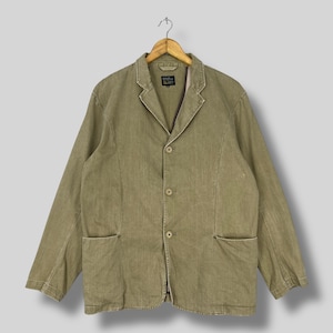 May include: A white ceramic mug with a black handle and the text "But First, Coffee" in a bold, black font. The mug is set against a blurred background, suggesting a cozy setting. The mug appears to be approximately 4 inches tall.