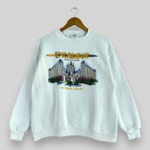 vintage EXCALIBUR sweat ras du cou moyen des années 90 Excalibur Hotel and Casino imprimé sportswear pull effet vieilli blanc taille M