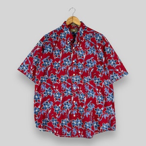 Puede incluir: Una camisa de manga corta de color rojo con botones y estampado floral azul y blanco.