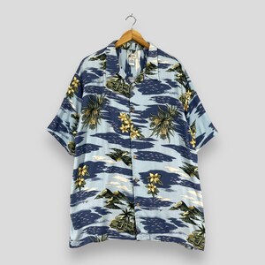 Può includere: Una camicia a maniche corte con bottoni blu e bianca con una stampa tropicale con palme, fiori e isole.