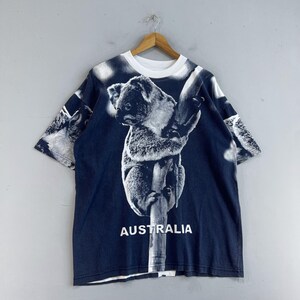 May include: A dark blue t-shirt with a white koala bear print and the word "AUSTRALIA" printed on the front.