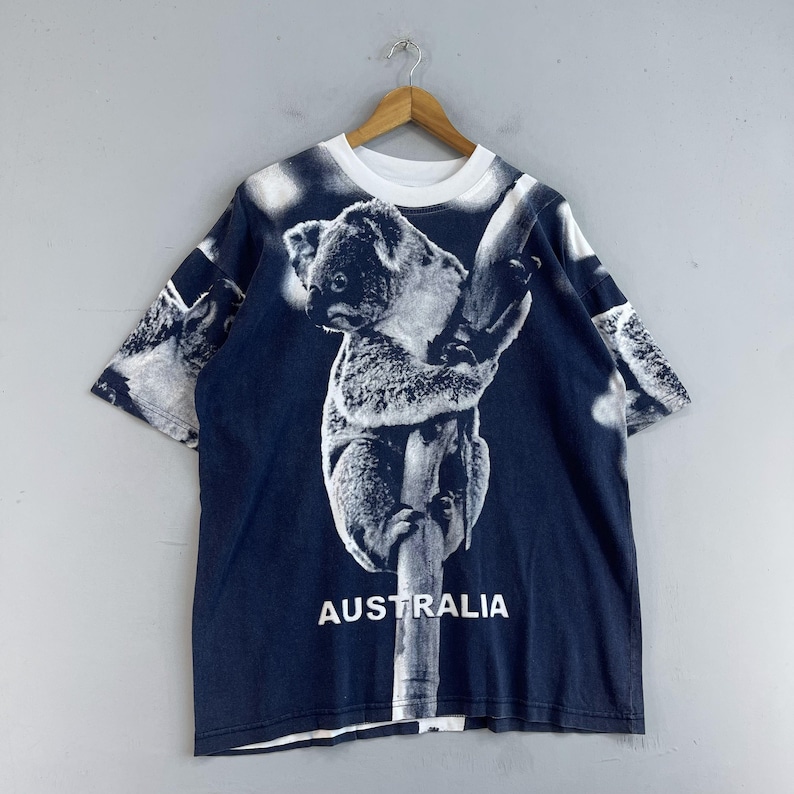 May include: A dark blue t-shirt with a white koala bear print and the word "AUSTRALIA" printed on the front.