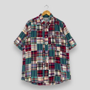 Könnte beinhalten: Ein kurzärmeliges Hemd mit Knöpfen und Patchwork-Muster. Das Hemd besteht aus verschiedenen karierten Stoffen in Rot, Grün, Blau und Weiß.