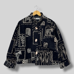 May include: Black corduroy jacket with cream-coloured embroidered animal and plant motifs. The jacket has a button-up front, long sleeves, and a collared neckline. The design includes rectangular patches with various embroidered images.