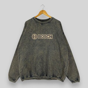 May include: A dark gray sweatshirt with a faded look, featuring a tan embroidered logo that says "BOSCH" with a circle around the "B".