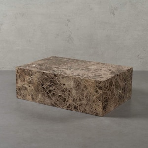 Könnte beinhalten: Ein rechteckiger Couchtisch aus braunem Marmor mit einem einzigartigen Maserungsmuster. Der Tisch hat ein massives, blockartiges Design und steht auf einer grauen Oberfläche. Der Marmor hat eine Mischung aus hellen und dunklen Brauntönen.