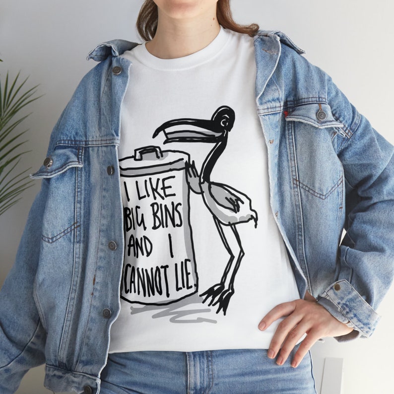 May include: White t-shirt with a black and white illustration of a bird with a trash can. The text on the trash can reads "I like big bins and I cannot lie."