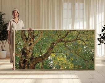 May include: A large framed artwork showing a tree with a thick, textured trunk and spreading branches. The artwork features green and yellow foliage, with a light-coloured frame. The artwork is held by a person.