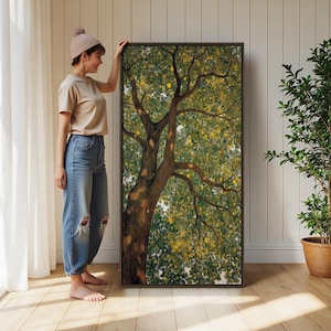 May include: A large rectangular framed wall art piece featuring a detailed painting of a tree with a thick brown trunk and dense green and yellow foliage. The artwork is displayed in a dark brown frame, showcasing a naturalistic view of branches.