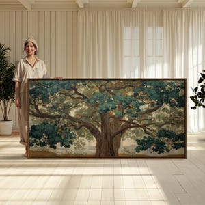 May include: A large rectangular landscape painting featuring a sprawling ancient tree with a thick brown trunk and dense, dark green foliage. The artwork is encased in a thin wooden frame, displaying a detailed forest scene with soft light.