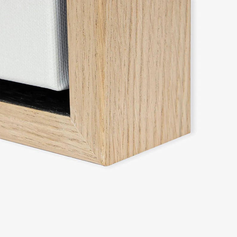 a close-up view of a wooden frame with a light-colored wood grain texture.