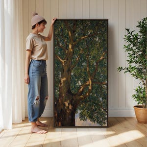 May include: A large rectangular framed wall art piece featuring a detailed painting of a tall tree with a thick, textured trunk and dense green foliage. The artwork is displayed in a dark frame, showcasing natural light and shadow patterns on the bark.