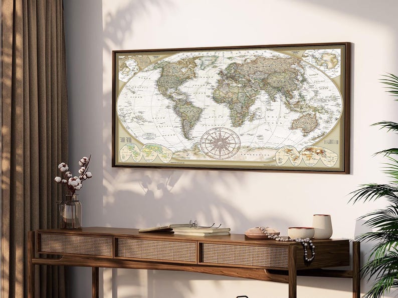 a large world map hanging on a wall above a wooden console table. The table has various items on it, including a vase with flowers, a book, and a pair of glasses.
