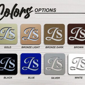 May include: A color chart showing different metal finishes for a personalized monogram. The monogram is the letters "IS" in a cursive font. The colors shown are gold, bronze light, bronze dark, brown, black, blue, silver, and white.