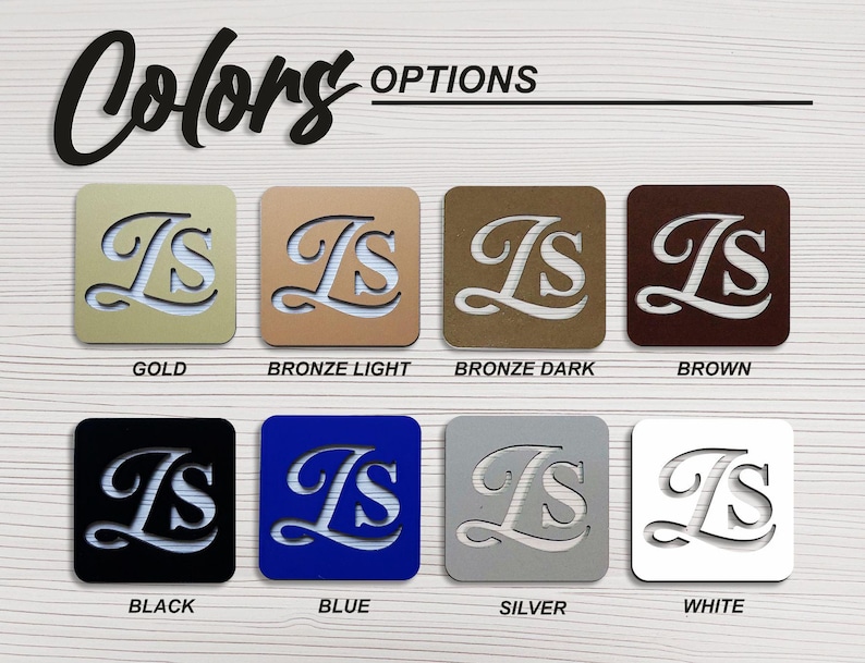 May include: A color chart showing different metal finishes for a personalized monogram. The monogram is the letters "IS" in a cursive font. The colors shown are gold, bronze light, bronze dark, brown, black, blue, silver, and white.