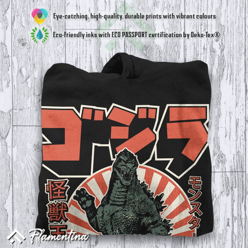 May include: Black hoodie featuring a vintage-style graphic of Godzilla in front of a red rising sun. The Japanese text reads "Gojira" and "Monster".