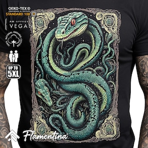 May include: A black t-shirt featuring a green snake design. The snake is coiled around itself and has a detailed, realistic appearance. The design is framed in an ornate border with a starry background. The shirt also displays the text "Flamentina" and several certifications, including "OEKO-TEX® STANDARD 100", "PITA APPROVED VEGAN", and "100% NATURAL ORGANIC COTTON".