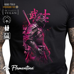 May include: A black t-shirt featuring a pink and black illustration of a samurai warrior holding a sword. The Japanese word "武士" (Bushi) is written in pink above the warrior. The text "Flamentina" is printed in white at the bottom of the shirt.