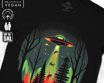 May include: Black t-shirt featuring a graphic of a UFO hovering over a forest with people falling from the sky. The text "Flamentina" is on the bottom of the shirt.