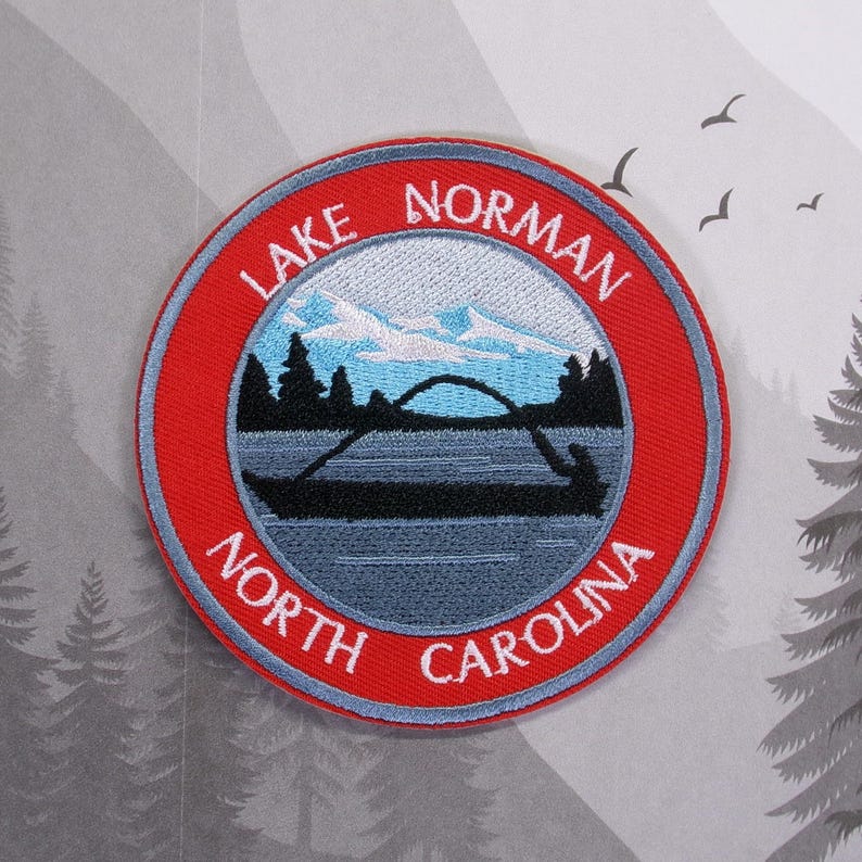 May include: Red, white and blue embroidered patch with the text "Lake Norman North Carolina" and a depiction of a lake with mountains in the background.