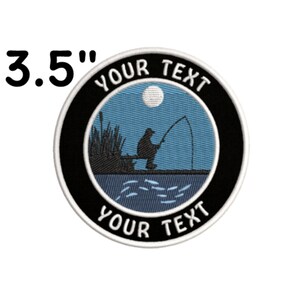 May include: A 3.5 inch round embroidered patch with a black background and a white border. The center of the patch features a blue night sky with a white moon, a silhouette of a person fishing, and the text "YOUR TEXT" in white.