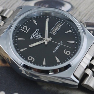 May include: A rustic wooden sign with the text "Welcome to our home" in white lettering. The sign features a distressed finish and a simple, inviting design, perfect for entryway decor.