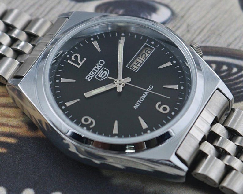 May include: A rustic wooden sign with the text "Welcome to our home" in white lettering. The sign features a distressed finish and a simple, inviting design, perfect for entryway decor.