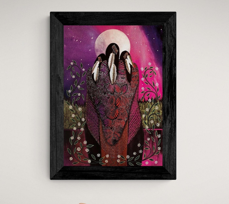 May include: Framed artwork featuring a vibrant depiction of three figures adorned with feathers, set against a backdrop of a full moon and a starry, pink and purple sky. The figures are draped in intricate, patterned garments.