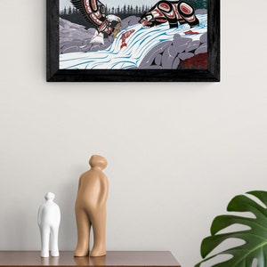 May include: A framed print of a stylized Native American art piece depicting a bear and an eagle fighting over a salmon in a river. The artwork is done in a colorful style with geometric shapes and patterns.
