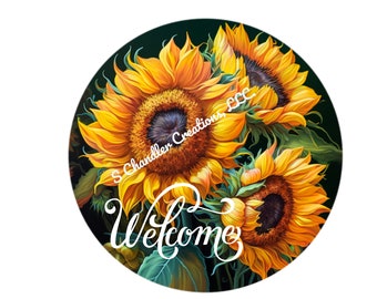 Op de afbeelding: Een rond welkomsbord met een donkergroene achtergrond en drie gele zonnebloemen. De zonnebloemen hebben donkere centra en zijn in een cluster gerangschikt. Het woord "Welkom" is geschreven in witte cursieve letters.