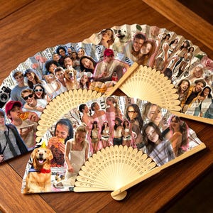 Op de afbeelding: Twee opvouwbare handwaaiers met lichtgekleurde houten ribben en een collage van diverse afgedrukte foto's met mensen, een golden retriever en een camera. De afbeeldingen zijn gerangschikt op een papieren oppervlak met krantenprint.