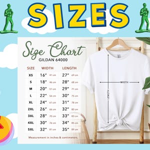 Op de afbeelding: Een wit Gildan 64000 t-shirt op een houten kledinghanger met een maattabel die afmetingen in inches en centimeters weergeeft. De tabel vermeldt maten van XS tot 5XL met bijbehorende breedte- en lengtematen voor elke maat.