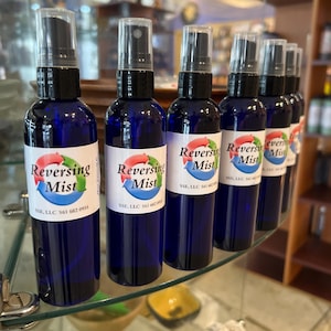 May include: Seven blue glass spray bottles with black tops and white labels that read "Reversing Mist" and "SSE, LLC 561 682 0955".