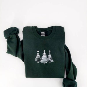 May include: A dark green sweatshirt with a white design of three stylized Christmas trees.